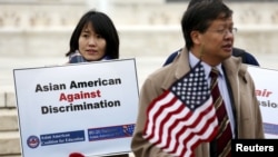 FILE - Asian-American demonstrators hold a rally outside the U.S. Supreme Court as it was hearing a case involving affirmative action in university admissions, Dec. 9, 2015. The case was brought white applicant Abigail Fisher, who claimed that a Universit