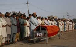 People attend the funeral of a security guard killed during a deadly attack on the Pakistan Stock Exchange in Karachi, June 29, 2020.