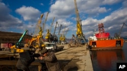 지난 2013년 11월 북한 라선경제특구에서 한 남성이 자전거를 끌고 새로 건설된 부두 주변을 지나고 있다. (자료사진)