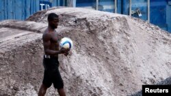 Un garçon circule avec un ballon dans une rue à Bata, Guinée équatoriale, 7 février 2015.