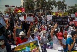 Pengunjuk rasa memamerkan plakat saat melakukan aksi protes di dekat Kedutaan Besar Indonesia (KBRI) di Yangon, Myanmar, Selasa, 23 Februari 2021.