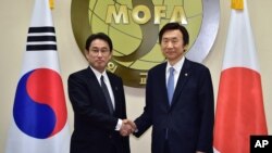 South Korean Foreign Minister Yun Byung-Se, right, and his Japanese counterpart Fumio Kishida pose for a photo at the start of their meeting at Foreign Ministry in Seoul, Dec. 28, 2015. 