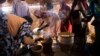Women use fuel-efficient cook stoves make their meals in a food distribution center in the Rwanda camp for internally displaced people (IDP) in Tawila, North Darfur, March 4, 2014.