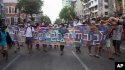 រូបឯកសារ៖ ក្រុម​បាតុករ​ដែល​ប្រឆាំង​នឹង​រដ្ឋប្រហារ​យោធា នាំ​គ្នា​កាន់​ស្លាកសញ្ញា​មួយ​ដែល​សរសេរ​ថា «អ្នក​នៅ​តំបន់​ភ្នំ​ និង​តំបន់​ដីគោក​រួបរួម​គ្នា» ក្នុង​អំឡុងពេល​ដែល​ពួកគេ​ធ្វើ​បាតុកម្ម​នៅ​ទីក្រុង​រ៉ង់ហ្គូន ប្រទេស​មីយ៉ាន់ម៉ា ថ្ងៃទី៣ ខែមិថុនា ឆ្នាំ២០២១។ 