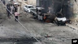 FILE - Syrian citizens gather near burned cars after airstrikes hit Manbij, in Aleppo province, Syria, in this undated image posted online on July 28, 2016, by supporters of the Islamic State militant group on an anonymous photo sharing website.