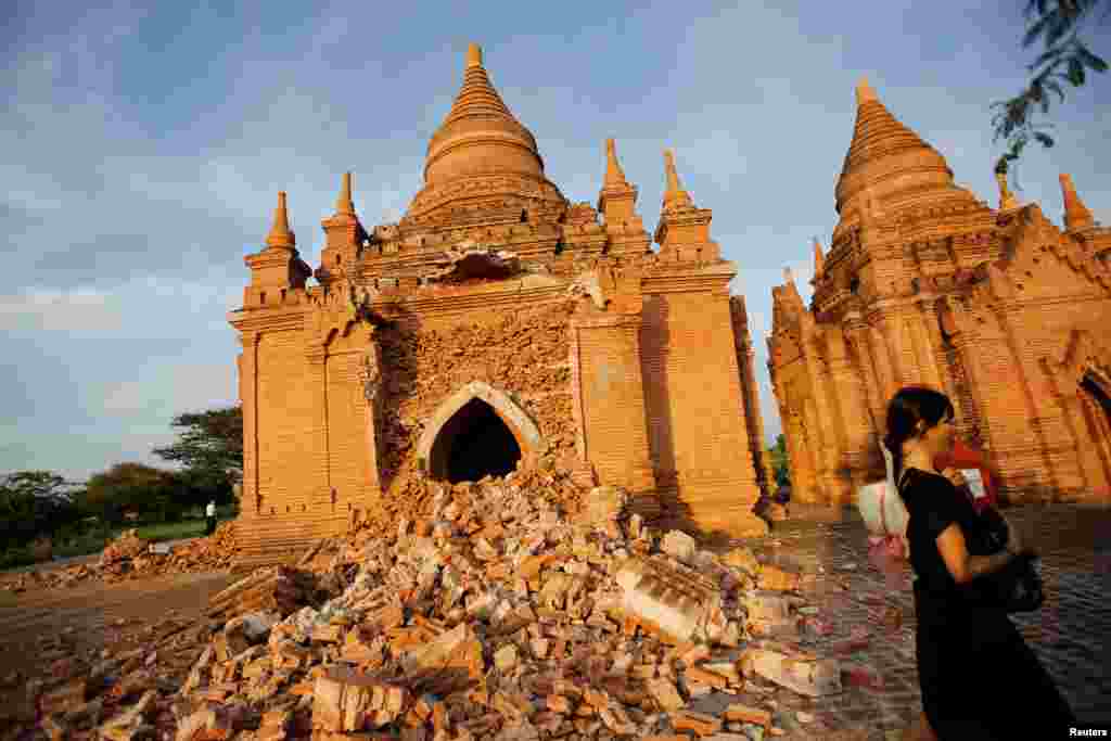 A woman walks past a damaged pagoda after an earthquake in Bagan, Myanmar, Aug. 25, 2016.