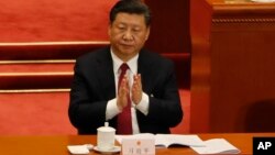 Chinese President Xi Jinping applauds China's Procurator-General Cao Jianming during a plenary session of China's National People's Congress, March 9, 2018, at the Great Hall of the People in Beijing.