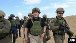 19일 가자지구를 방문한 베냐민 네타냐후 이스라엘 총리가 주둔 병력과 함께 걷고 있다.