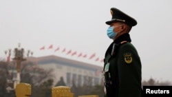 FILE - A paramilitary police officer stands guard near the Great Hall of the People in Beijing, China, March 5, 2021. A U.S. intelligence report released April 13, 2021, warned of China's threat to the U.S.
