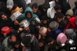 Palestinians receive food rations at a donation point at a camp for internally displaced people in Rafah, Gaza Strip, on Feb. 2, 2024.