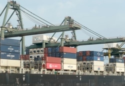 지난 5월 베트남 호치민 사이공항에서 화물 운반선에 컨테이너를 싣고 있다.