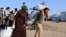 Syrian displaced families, who fled violence after the Turkish offensive in Syria, receive aid in Bardarash refugee camp on the outskirts of Dohuk, Iraq Oct. 22, 2019.