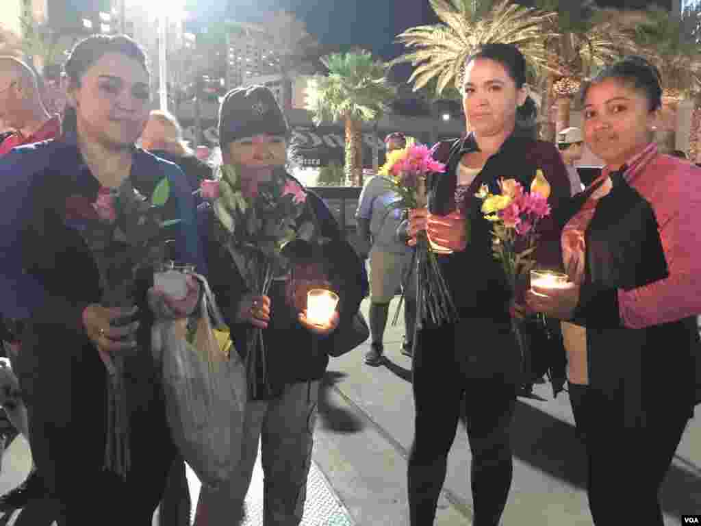 A group of women carry candles and flowers to vigil for victims of Las Vegas mass shooting, Oct. 2, 2017. (Photo: C. Mendoza / VOA) 