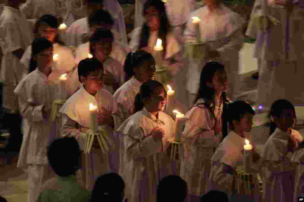 Christians hold candles during Christmas eve mass service at the cathedral in Bali, Indonesia, Dec. 24, 2013.