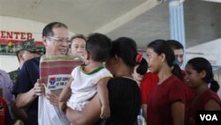 Presiden Benigno Aquino III (berkacamata) ikut membagikan bantuan kepada korban badai di kota Iligan, Filipina selatan (20/12).
