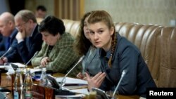 러시아 정부 비밀 요원으로 활동한 혐의로 구속된 마리아 부티나(오른쪽)가 러시아 정부 소속 전문가들의 회의에 참석하고 있다. (자료사진)