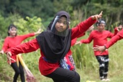 Dancers wearing face shields to prevent the spread of the coronavirus perform in Tangerang, Indonesia, Nov. 28, 2020,