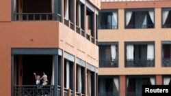 A woman plays with a child on the hotel terrace in H10 Costa Adeje Palace, which is on lockdown after novel coronavirus has been confirmed in Adeje, on the Spanish island of Tenerife, Spain, Feb. 27, 2020. 