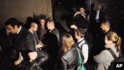 FILE - Workers from a non-governmental organization National Democratic Institute, or NDI, wait as Egyptian officials raid their office in Cairo, Egypt, Thursday, Dec. 29, 2011.