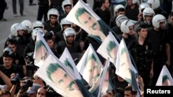 FILE - Demonstrators hold flags picturing imprisoned Kurdish rebel leader Abdullah Ocalan, during a protest against latest security operations in Diyarbakir, Turkey, Sept. 6, 2015.