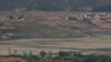 North Korea's Kaepoong town is seen behind a North Korean military guard post, bottom, from the unification observatory in Paju, South Korea, May 6, 2019. North Korea says it is suffering its worst drought in decades amid concern of a food crisis..
