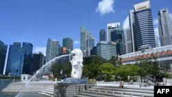 A man rests along Merlion park in Singapore on May 15, 2020. (Photo by Roslan RAHMAN / AFP)