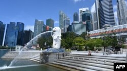 A man rests along Merlion park in Singapore on May 15, 2020. (Photo by Roslan RAHMAN / AFP)