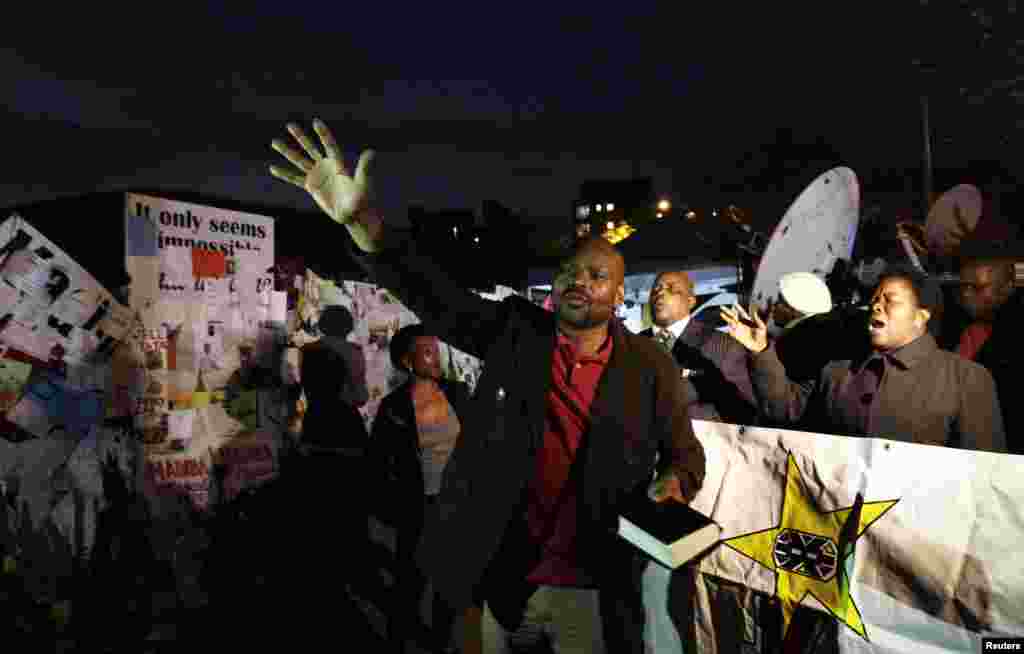 Well-wishers pray in support of ailing former South African President Nelson Mandela in front of the Mediclinic Heart Hospital where he is being treated in Pretoria, July 5, 2013.