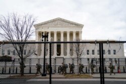 미국 워싱턴에서 조 바이든 대통령 당선인 취임식을 앞두고 경계 태세가 강화된 가운데, 18일 주방위군 병력이 의사당 주변 대법원 건물 앞을 지나고 있다. 건물 주변에도 철책이 설치됐다.