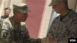 Jenderal AS David Petraeus (kiri) menyerahkan komando pasukan internasional di Afghanistan kepada penggantinya, Jenderal AS John Allen, Senin (18/7).