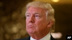 President-elect Donald Trump speaks with reporters in the lobby of Trump Tower in New York, Friday, Jan. 13, 2017.