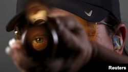 Shooting competitor Kim Rhode looks down the barrel of her shotgun as she poses for a portrait at the U.S. Olympic Committee Media Summit in Los Angeles, California, March 8, 2016. (REUTERS/Lucy Nicholson)