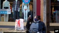 Žena pravi pauzu tokom šopinga, dok pandemija Kovida 19 i dalje traje, u Santa Moniki, Kalifornija, 9. juna 2021. (Foto: AP, Marsio Hose Sančez)