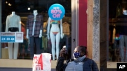 FILE - A shopper takes a break amid the COVID-19 pandemic on The Promenade, June 9, 2021, in Santa Monica, Calif. 