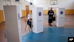 Orang-orang mempersiapkan TPS di Mitrovica yang diominasi oleh Serbia, Kosovo, 8 Juni 2014. 