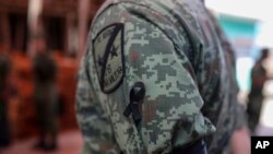 A Mexican soldier wears a black ribbon during the wake for Alfredo Gonzalez Munoz, a fellow soldier who died in a gun battle in the city of Culiacan between drug cartel gunmen and members of the army and the police, in Veracruz, Mexico, Oct. 19, 2019.