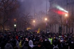 Protesters stand on the Place de la Republique in Paris during clashes at a demonstration against French government pension reform plans as part of a day of national strikes and protests, Dec. 5, 2019.