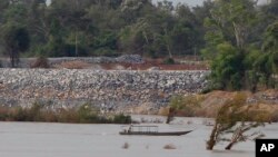 ឯកសារ៖ នៅ​ក្នុង​រូបថត​នៅ​ថ្ងៃ​ទី​២០ ខែ​មិថុនា ឆ្នាំ​២០១៦​នេះ គេ​ឃើញ​ទូក​នេសាទ​មួយ​បើក​កាត់​ក្បែរ​ការដ្ឋាន​ទំនប់ Don Sahong នៅ​ជិត​ព្រំដែន​កម្ពុជា​ឡាវ នៅ​ភូមិ​ព្រះរំកិល ខេត្ត​ស្ទឹងត្រែង។