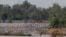 FILE - In this June 20, 2016 photo, a fishing boat passes near a construction site of the Don Sahong dam, near Cambodia-Laos borders, in Preah Romkel village, Stung Treng province, northeast of Phnom Penh, Cambodia.