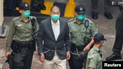 资料照：香港壹传媒创办人黎智英戴着手铐从一辆警车走向法庭。（2020年12月12日）