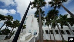 FILE - A police officer stands beside an entrance to the Alto Lee Adams Sr. U.S. Courthouse, Aug. 15, 2023, in Fort Pierce, Florida, where the case against Donald Trump for retaining classified documents after leaving office is being considered.