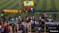Les joueuses des équipes Al-tahadi (en vert) et Al-Difaa (en jaune) avant le premier match de football féminin du Soudan au stade de Khartoum, le 30 septembre 2019.