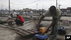 Due to Nigeria's decrepit national power grid, a man refuels a small generator in central Lagos, August 2010.