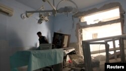FILE - A medic inspects the damage inside Anadan Hospital, sponsored by Union of Medical Care and Relief Organizations, after it was hit by an airstrike in the rebel-held city of Anadan, northern Aleppo province, Syria, July 31, 2016.