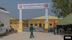 អាជ្ញាធរយាមល្បាតនៅខាងមុខមជ្ឈមណ្ឌលចត្តាឡីស័កប្រចាំរាជធានីភ្នំពេញ ដែលត្រូវបានប្រែក្លាយទៅជាមន្ទីរពេទ្យបណ្តោះអាសន្នដើម្បីព្យាបាលអ្នកជំងឺកូវីដ១៩ កាលពីថ្ងៃទី២៦ ខែកុម្ភៈ ឆ្នាំ២០២១។ (ទុំ ម្លិះ/វីអូអេ)