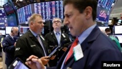 Traders work on the floor of the New York Stock Exchange (NYSE) in New York City, June 25, 2018. 