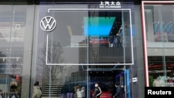 Ljudi prolaze pored izložbenog prostora SAIC Volkswagena u Čengduu, provincija Sečuan, Kina, 10. januara 2021.