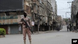 A security personnel stands guard after the government announced a citywide lockdown with concerns over the spread of the coronavirus in Hyderabad, Pakistan, March 23, 2020. 