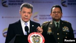 Presiden Kolombia Juan Manuel Santos (kiri), didampingi kepala polisi Jenderal Jorge Nieto dalam konferensi pers di Bogota (17/2). (Reuters/John Vizcaino)