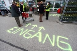 Security employee disinfects shopping carts at the entrance of a garden store in Munich, Germany, April 20, 2020.
